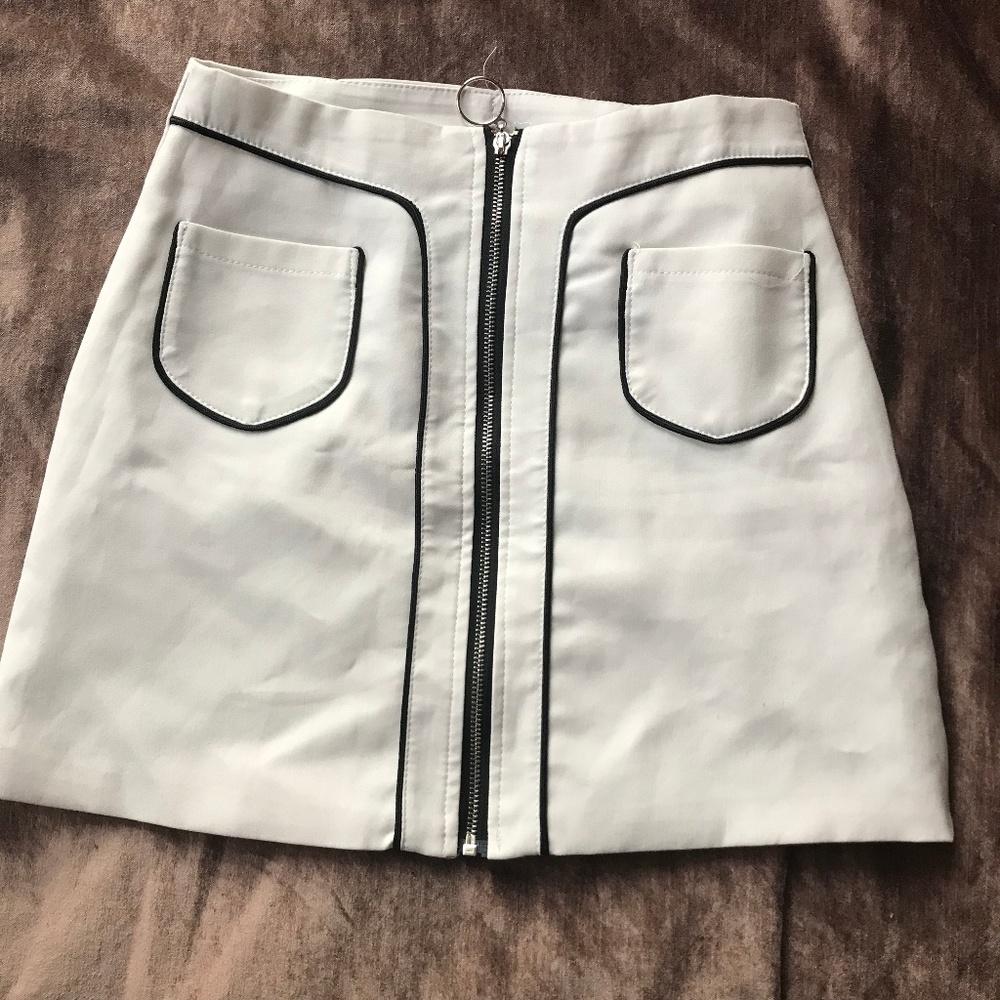 White mini skirt with black zipper and pockets